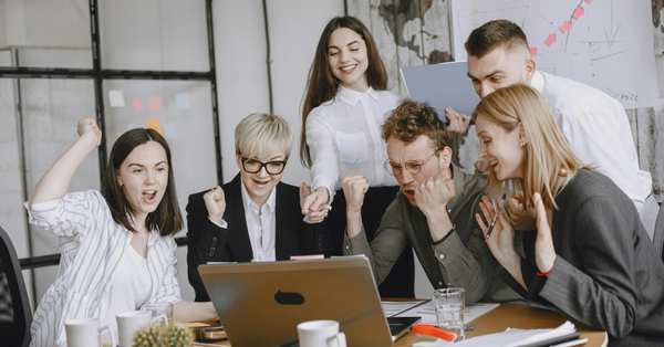 Iloisia ihmisiä tietokoneen äärellä. 