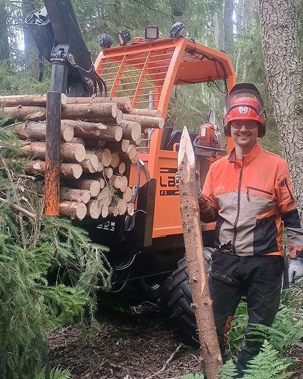 Metsuri seisoo koneen vieressä kädessään kuusenrungosta tehty tolppa.