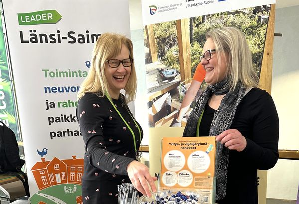 Kaksi henkilöä yritysinfon esittelypisteellä