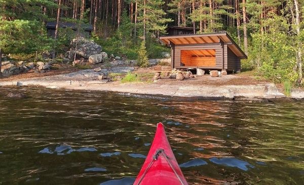 Kajakin keula osoittaa saareen, jossa on rannalla laavu.
