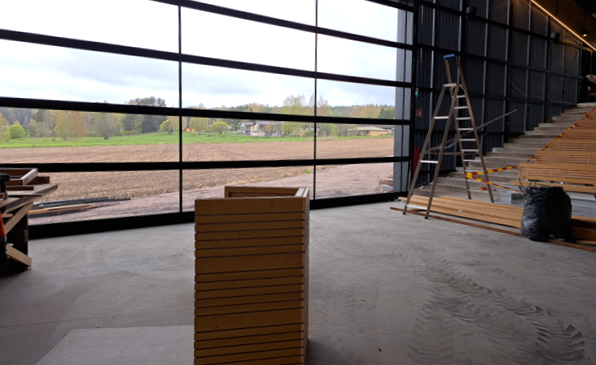 Kuva areenan sisätilasta, jossa näkyy suuri ikkuna, katsomoa ja puhujan pönttö.