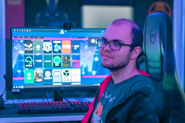 Kuvassa henkilö istuu pelitietokoneen edessä.