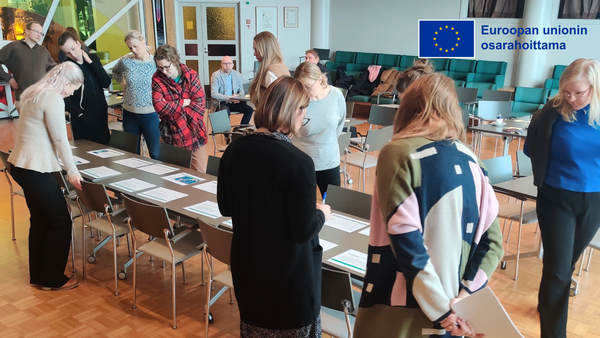 Ihmisiä seisomassa pöydän ääressä.