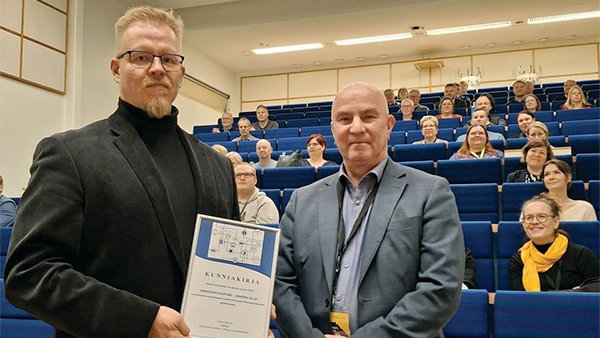 kaksi miestä katsoo kameraan