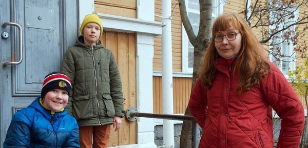 Rakennustyömaalla hiekkakenttä, kaivinkone, kerrostaloja ja nosturi