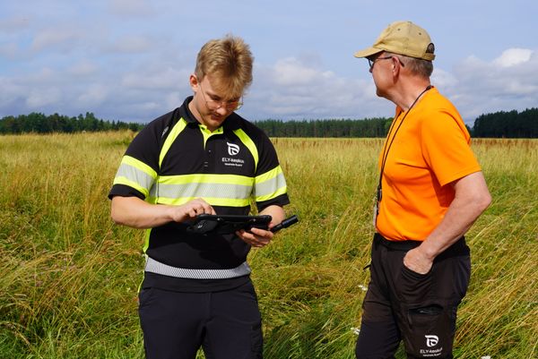 Kaksi tarkastajaa pellolla.