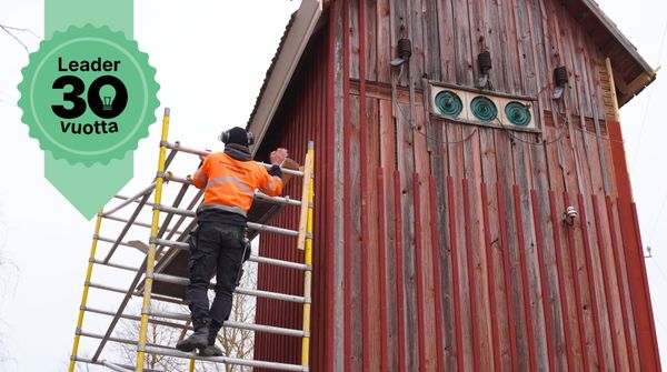Mies muutamon vieressä rakennustelineillä.