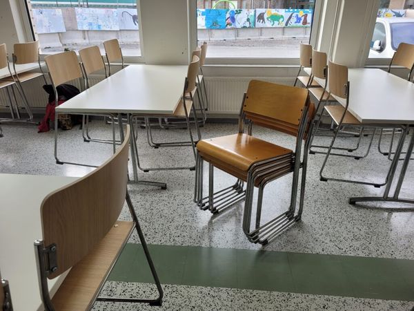 Pöytiä ja tuoleja koululuokassa.