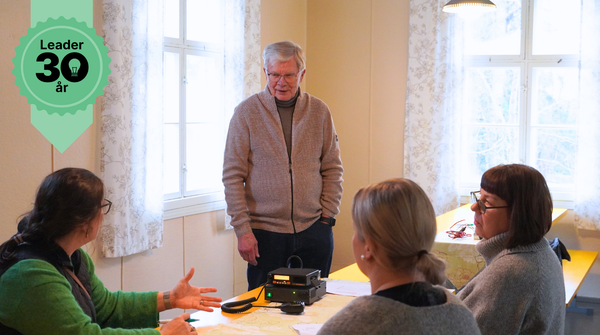 Ihmiset tutkivat radiota pöydän ääressä.