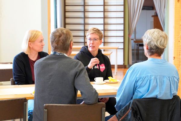 Ihmisiä kahvipöydässä.