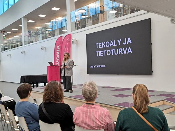 Kuvassa Laura Kankaala lavalla puhumassa tekoälystä ja tietoturvasta.