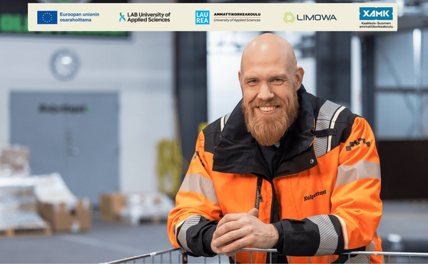 Kuvassa työvaatteisiin pukeutunut mies katsoo kameraan ja hymyilee