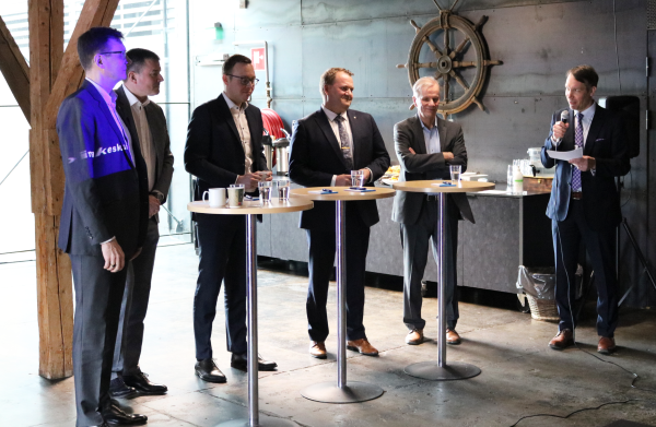 Paneelistit yleisön edessä.