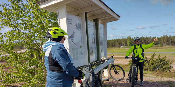 Neljä ihmistä pöydän ääressä tutustumassa radioon.
