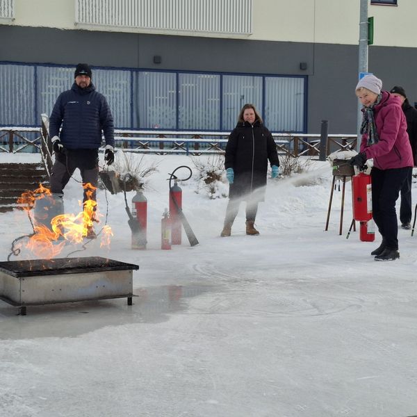 Ihmisiä harjoittelemassa tulen sammuttamista.