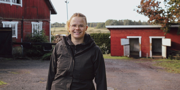 Nuori viljelijä Loviisa Mäkipere hevostallin edessä