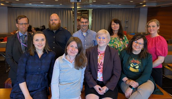 Tulevaisuuden työmarkkinat -hankkeen yhdeksänhenkinen tiimi poseeraa kokoushuoneessa.
