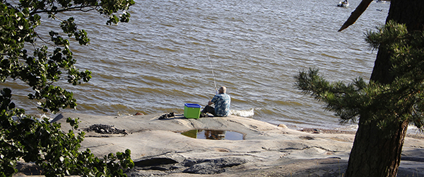 Kalastaja meren rannalla.