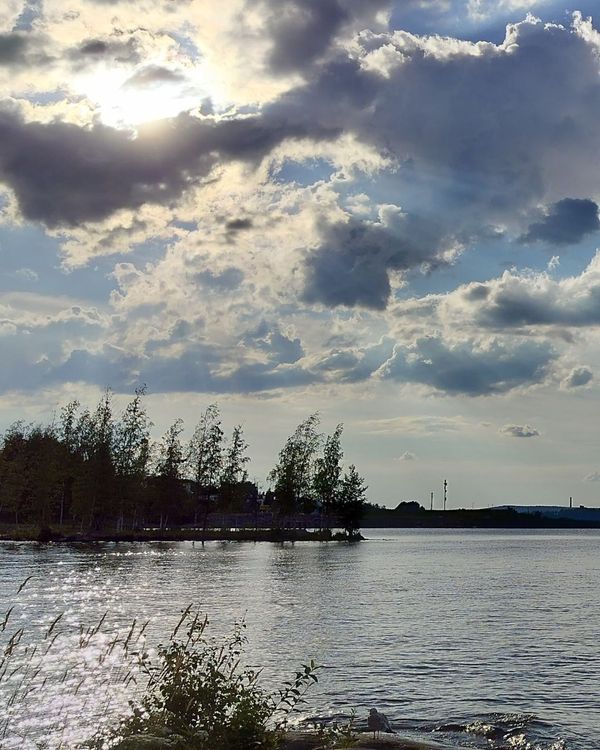 vesistöä ja aurinko paistaa pilven takaa kesällä.