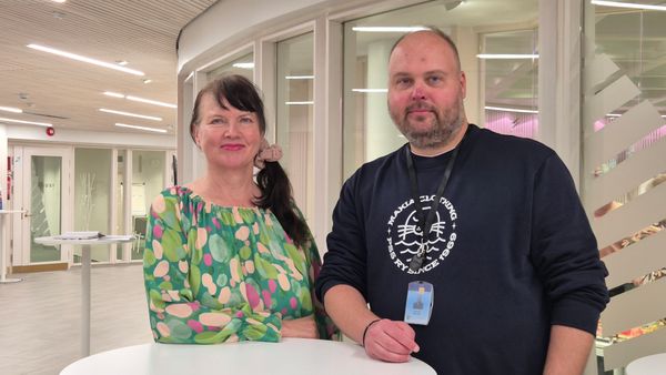 alla olevan blogin kirjoittajat, kaksi ihmistä seisoo valkoisen pöydän takana