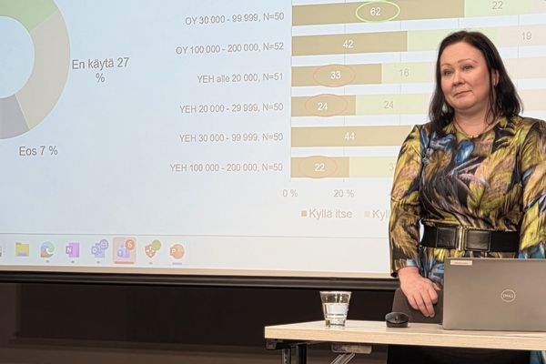 nainen seisoo esityksen edessä.