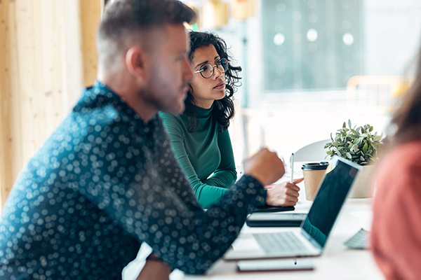 Ihmisiä pöydän ääressä keskustelemassa.