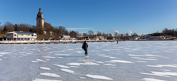 Ihmisiä jäällä kaupungin edustalla.